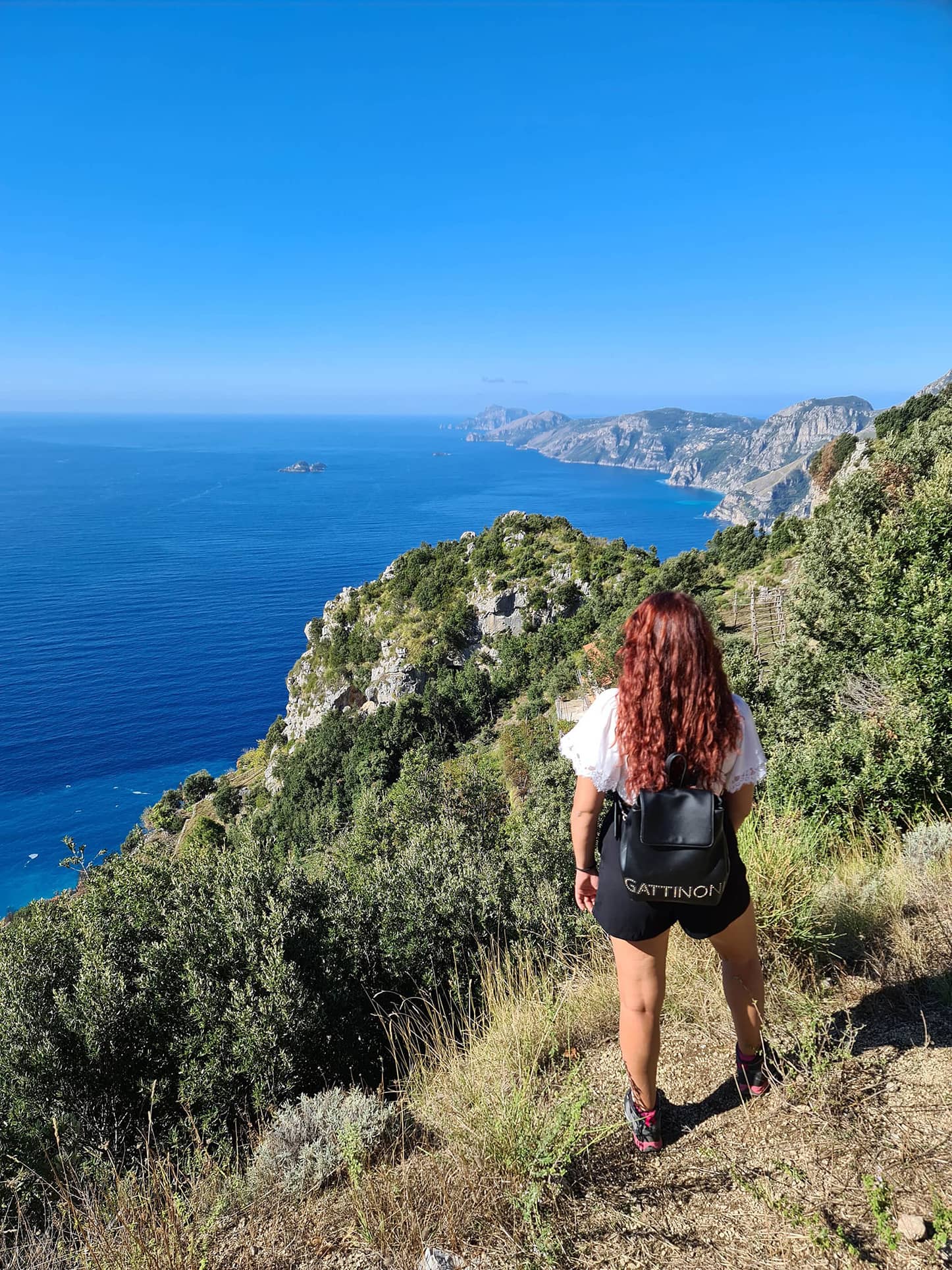 Carlotta di spalle sul Sentiero degli Dei, mentre guarda il panorama sulla Costiera Amalfitana