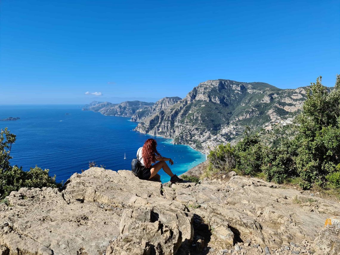 Carlotta seduta su una roccia mentre guarda il panorama sulla Costiera Amalfitana durante il Sentiero degli Dei