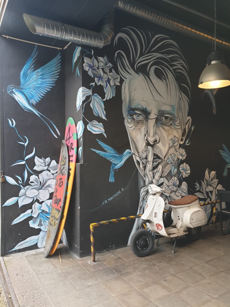 Murales raffigurante David Bowie con una vespa appoggiata sul muro