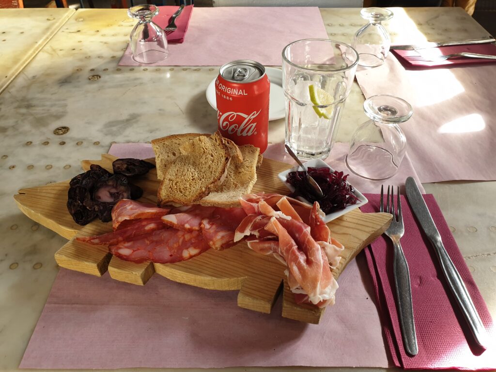 in foto si vede un tagliere di salumi ed una lattina di coca-cola