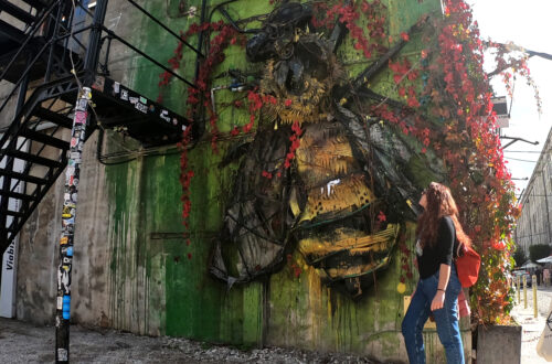 Carlotta in piedi mentre osserva una delle opere di street art a LX factory
