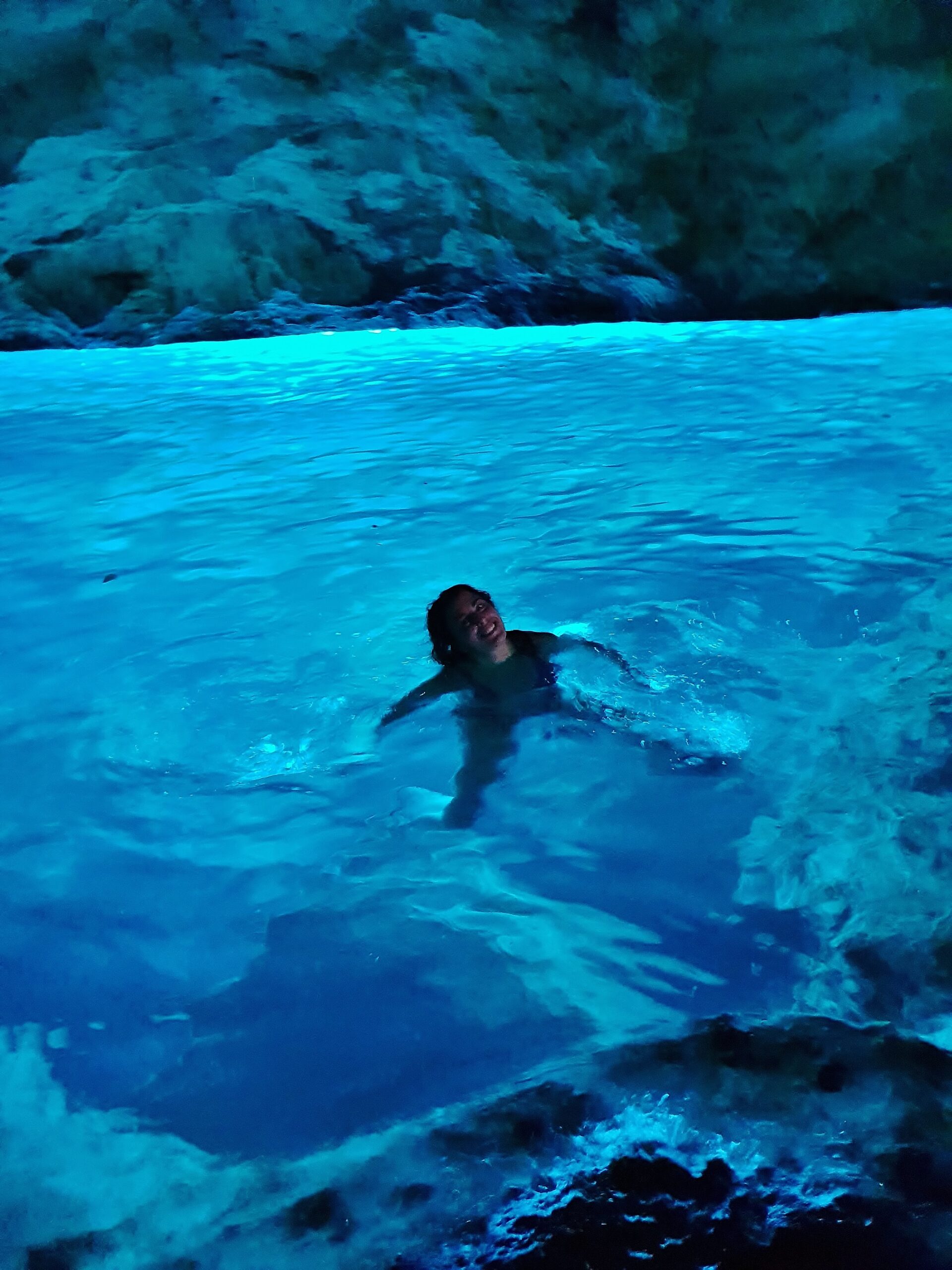 Carlotta mentre fa il bagno nella grotta verde, una delle grotte marine del Salento sulla Costa Adriatica, dove l'acqua assume un colore azzurro chiaro