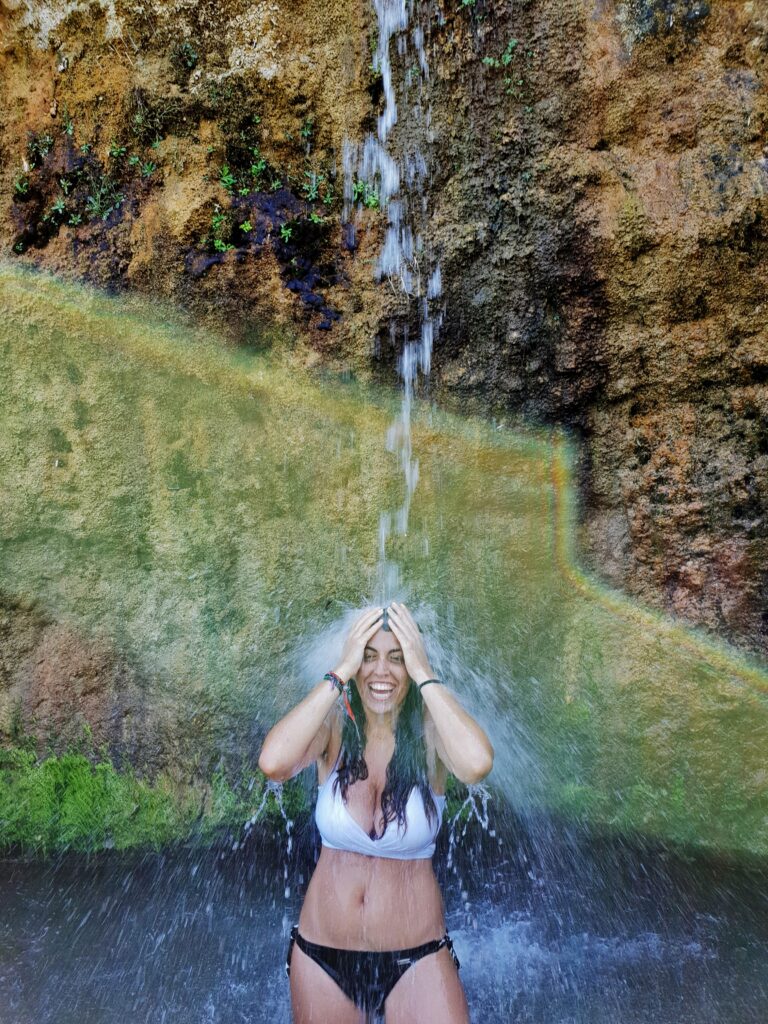 Carlotta sotto il getto di una piccola cascata di acqua dolce in località Grotta della Monaca