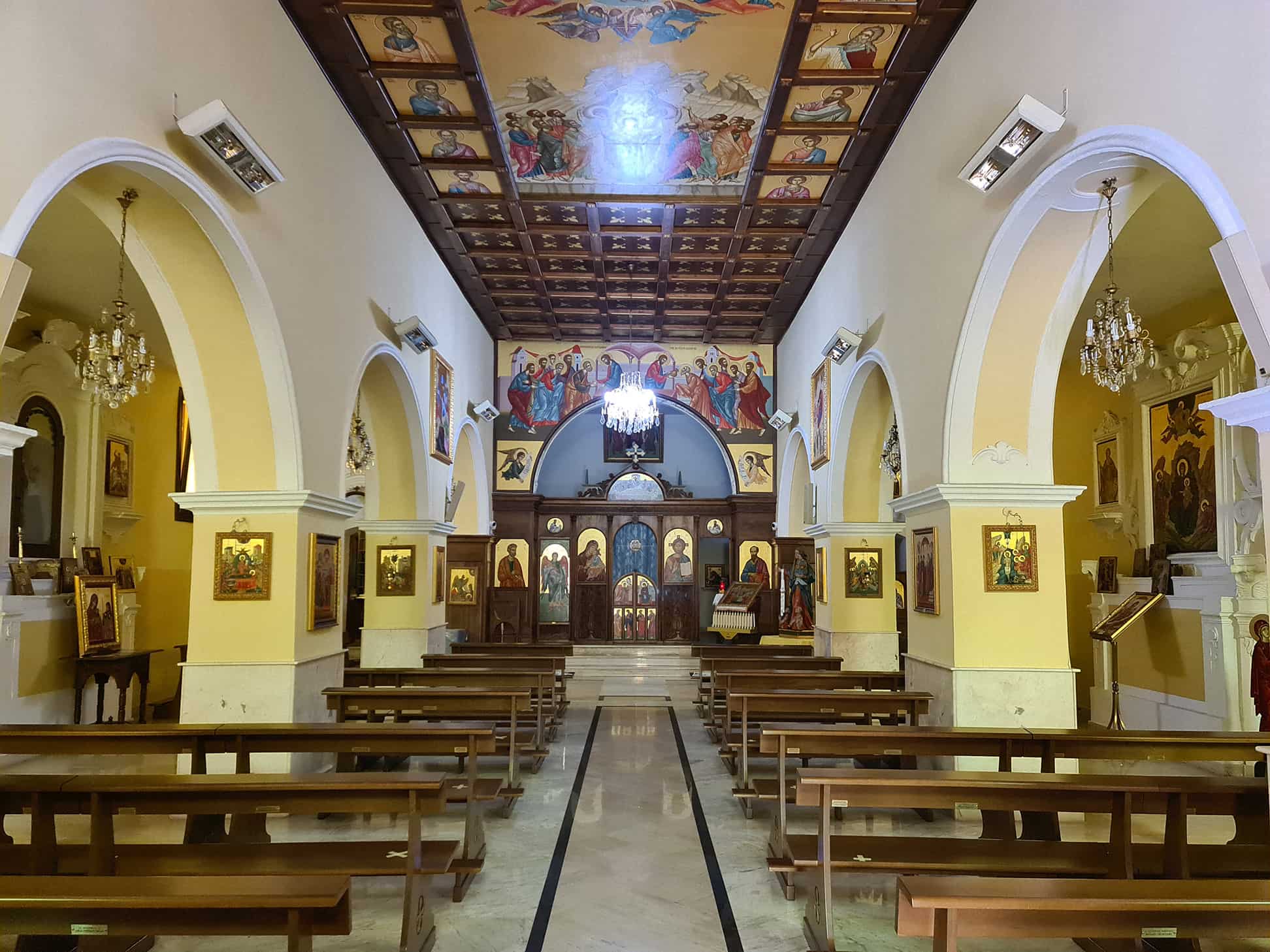 Una foto della chiesa di San Paolo albanese con il soffitto in legno e l'altare con diverse icone religiose