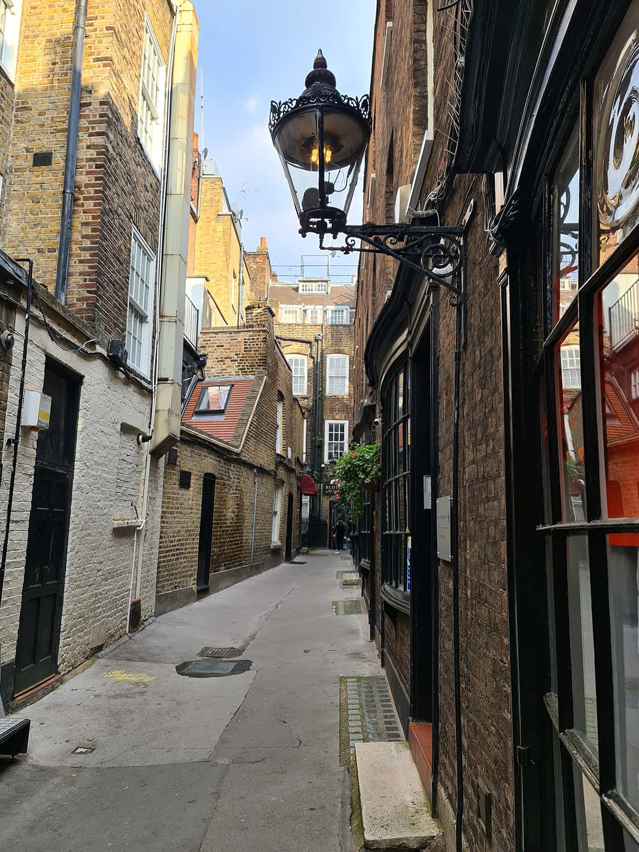 In foto si vede un vicolo, caratterizzato da un lampione nero e alcuni negozi con porte dipinte di nero, che è stato d'ispirazione per la Rowling per creare Nocturne Alley, uno dei luoghi di Harry Potter a Londra