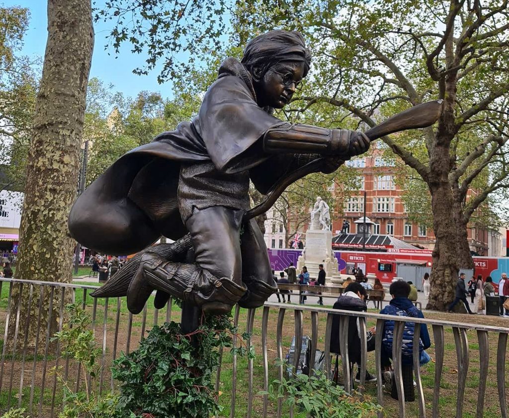 Una foto della statua di Harry Potter sopra la scopa volante, che si trova a Leicester Square