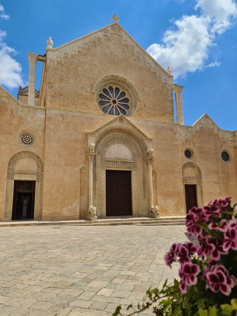 Una foto della facciata sobria della Basilica di Santa Caterina, con un rosone al centro ed un portone circondato da due colonne.